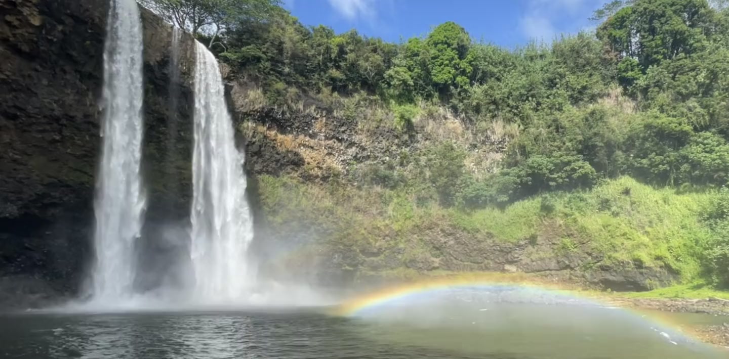 Wailua Falls auf Kauaʻi mit einem Regenbogen über dem Wasser
