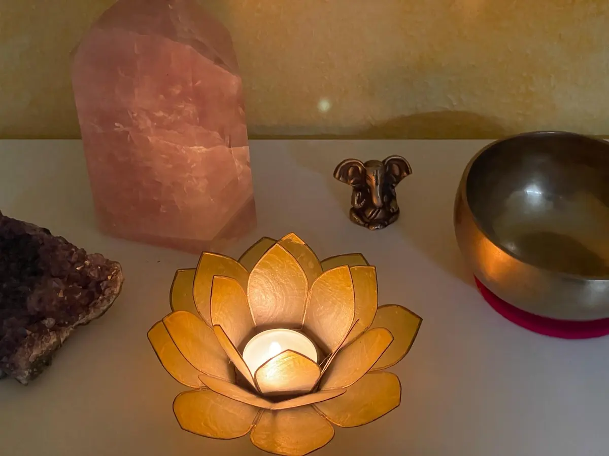Kerzenlicht, Kristalle und Klangschale als Praxisdetail